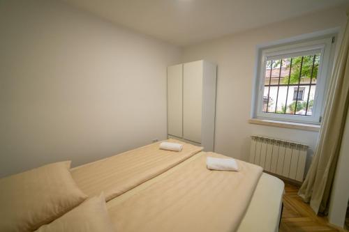 a bedroom with a large bed with two towels on it at Four Seasons Apartments in Sarajevo