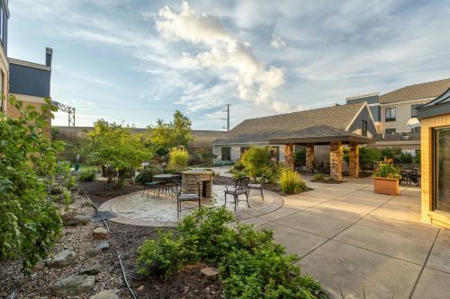 a patio with tables and chairs in a yard at Staybridge Suites Middleton/Madison-West by IHG in Middleton