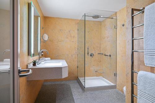 a bathroom with a glass shower and a sink at Malta Marriott Resort & Spa in St Julian's