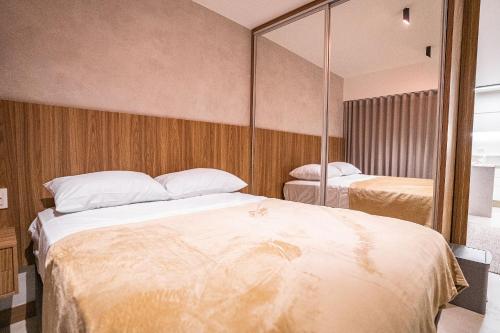 a bedroom with two beds and a large mirror at Apartamento novo de alto padrão e aconchegante#223 in Brasilia