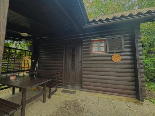 a cabin with a table and benches in front of it at Teddy in Čatež ob Savi