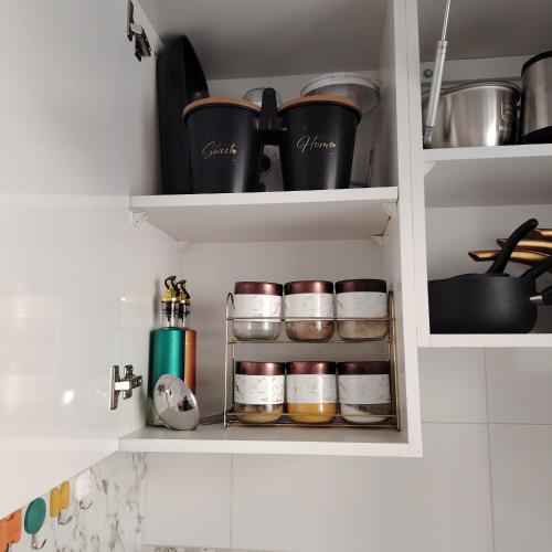 a kitchen pantry with spices and other kitchen items at Élégance familiale à Skhirate près de la plage et la ville in Skhirat