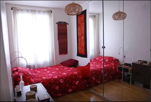 - une chambre avec un lit rouge et une table dans l'établissement Quiet APT 2Rooms Big Kitchen Canal Saint Martin, à Paris
