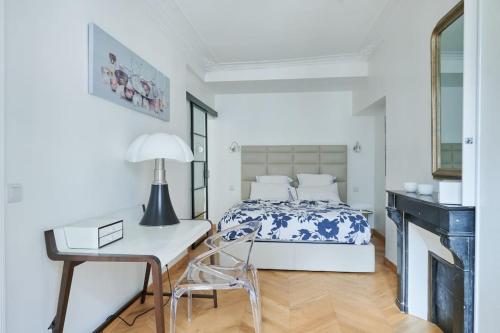 une chambre avec un lit, un bureau et une chaise dans l'établissement Appartement type F2 rénové- Quartier Elysée, à Paris