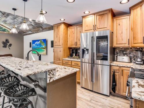 a kitchen with wooden cabinets and a stainless steel refrigerator at Luxury Single Level, Great Location, Hot Tub, Arcade in South Lake Tahoe