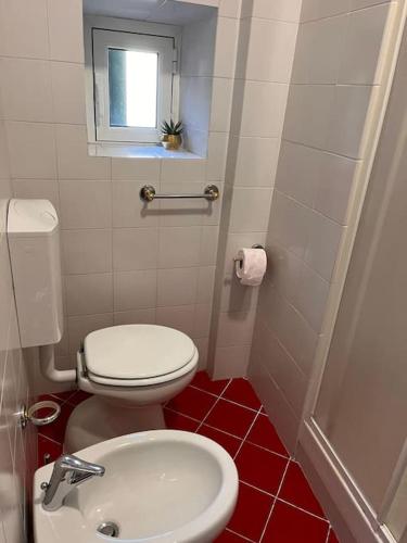 a bathroom with a white toilet and a sink at Andromeda Holiday 1 C in Genoa