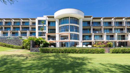 an apartment building with a lawn in front of it at ❤PiH❤ Hapuna Beachfront Bliss Beachfront Steps From Ocean B29 in Hapuna Beach