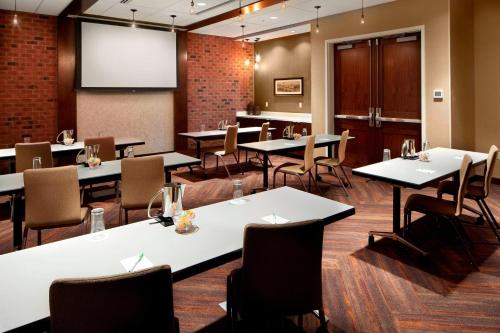 a conference room with tables and chairs and a projection screen at Courtyard Charlotte Fort Mill, SC in Fort Mill