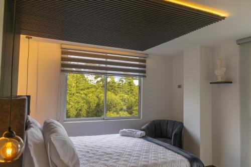 锡卡西亚Piso en el Quindío, apartamento de lujo的带床和窗户的卧室