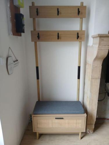 une étagère en bois avec un banc dans une pièce dans l'établissement Petite maison studio cosy avec jardin, à Saint-Honoré-les-Bains