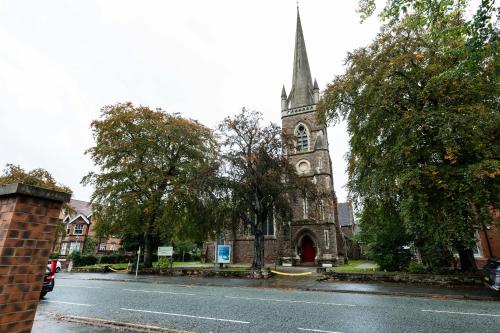 an old church with a clock tower on a street at Luxury Modern Flat In Wolverhampton- Garden Views in Wolverhampton