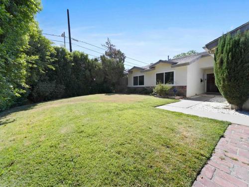 a backyard of a house with a grass yard at Retreat with Pool in Los Angeles
