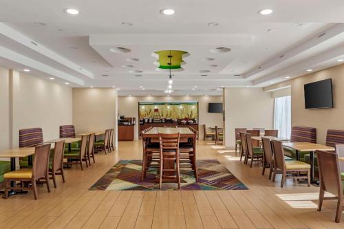 a dining room with tables and chairs and a bar at Best Western Plus North Shore Hotel in Danvers