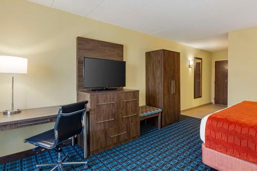 a hotel room with a bed and a desk and a television at Best Western Plus North Shore Hotel in Danvers