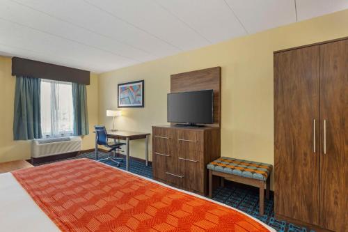 a hotel room with a bed and a flat screen tv at Best Western Plus North Shore Hotel in Danvers