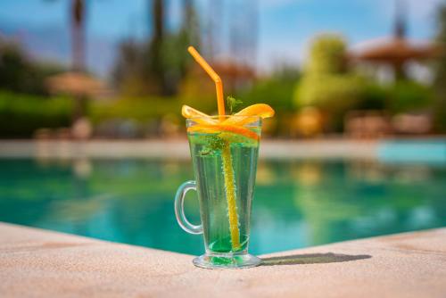 a drink with an orange slice in a cup next to a pool at RIMALIZ House in Amizmiz