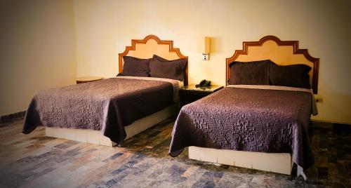 two beds in a hotel room with two beds at Hotel Paraiso in Puerto Peñasco
