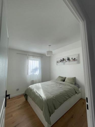 une chambre blanche avec un lit et une fenêtre dans l'établissement Appartement de L, à Saint-André-de-Cubzac