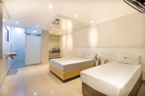 圣保罗Hotel Age - Próximo Arena Corinthians e Aeroporto de Guarulhos的一间带两张床的卧室和一间浴室
