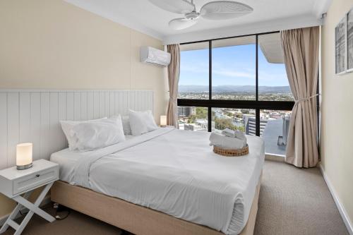 a bedroom with a large white bed with a window at Oceanfront 24th Floor 1 Bedroom Retreat with Stunning Views & Free Parking in Gold Coast