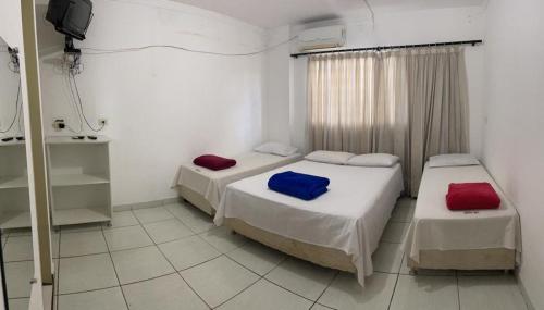 a room with two beds and a television in it at Hotel Santos Reis in Trindade