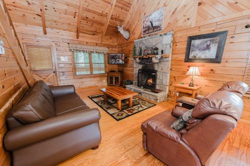 a living room with leather furniture and a fireplace at A Dream Come True cabin in Sevierville