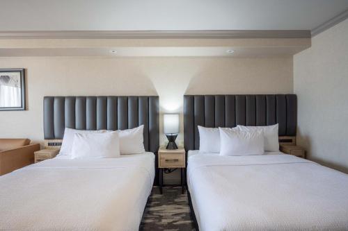 two beds sitting next to each other in a hotel room at Sandman Hotel & Suites Winnipeg Airport in Winnipeg