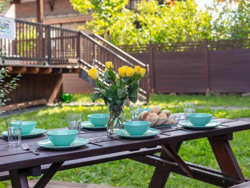 a wooden table with plates and bowls and a vase of flowers at Schönfeld I in Kitzbühel