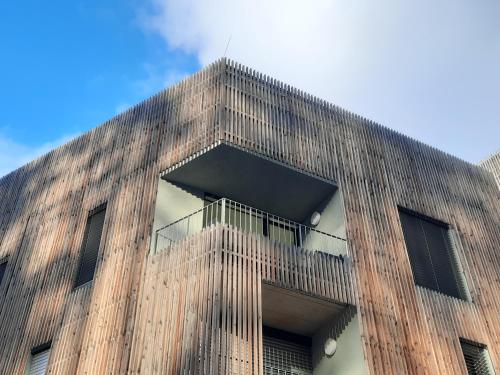 a tall wooden building with a balcony at Pod hrází & Sedmé nebe in Staré Splavy