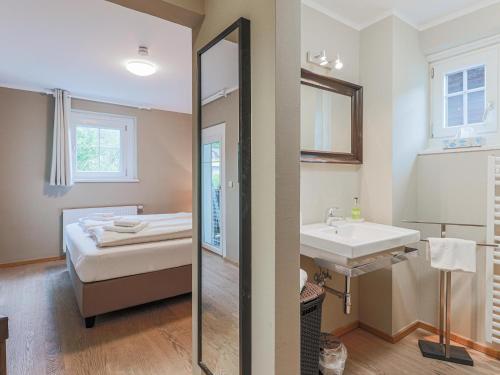 a bathroom with a bed and a sink and a mirror at Schönfeld I in Kitzbühel