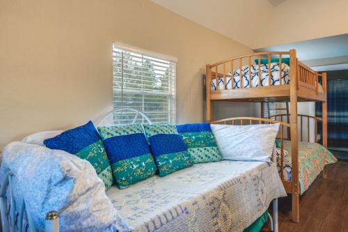 a room with a couch with blue and green pillows at Plantersville Cabin on 50 Acres with Pond and Fire Pit in Magnolia