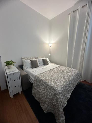 una camera da letto con un letto e un tavolo con una lampada di L'Attichetto di via Padova a Roma