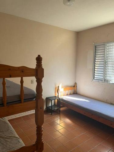 a bedroom with two bunk beds and a window at Apartamento Itaguá in Ubatuba