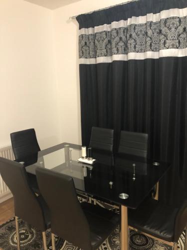 una sala conferenze con tavolo e sedie in vetro di Luxury Kingsize Bedroom with Private Bathroom a Northolt