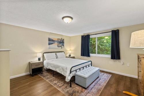 a bedroom with a bed and a chair and a window at Modern Mountain Cottage w Hot Tub, Fire Pit, WiFi in Inwood
