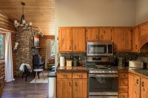 a kitchen with wooden cabinets and a stove top oven at Gorgeous Cabin 3 Rooms & 2 Baths in Bailey