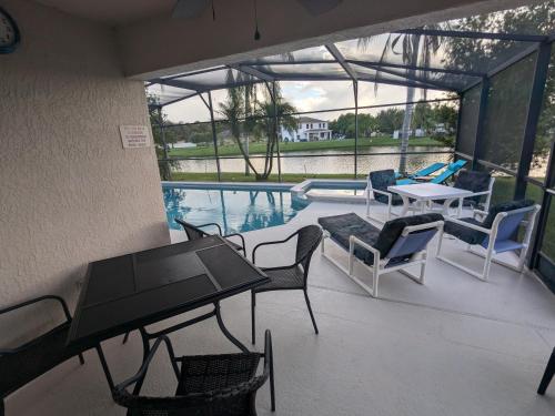 a patio with a table and chairs and a pool at Large lakeside 5 bed villa with private pool in Kissimmee
