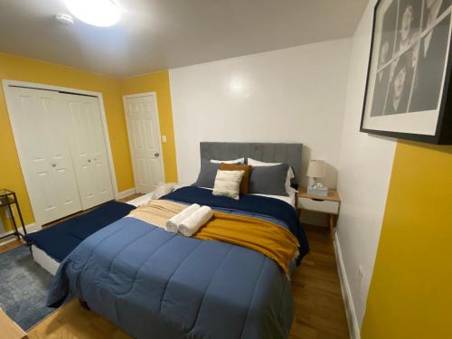 1 dormitorio con 1 cama con sábanas azules y paredes amarillas en Live in NYC -20 Mins to Rockefeller, MoMA & World, en Jersey City
