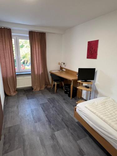a hotel room with a desk and a bed at Steinberger Hof Übernachtungen in Rinteln