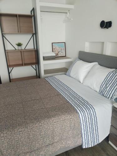 a bedroom with a bed and a book shelf at Departamento con HERMOSA VISTA AL PACÍFICO in Huanchaco