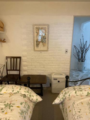 a bedroom with two beds and a chair at Gallery HARA and guest house in Hara