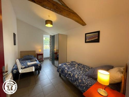 ein Schlafzimmer mit zwei Betten und einem Tisch mit Lampe in der Unterkunft Gîte rénové avec spa, piscine chauffée, WiFi et accès handicapés au cœur du Marais Breton - FR-1-426-321 in Soullans
