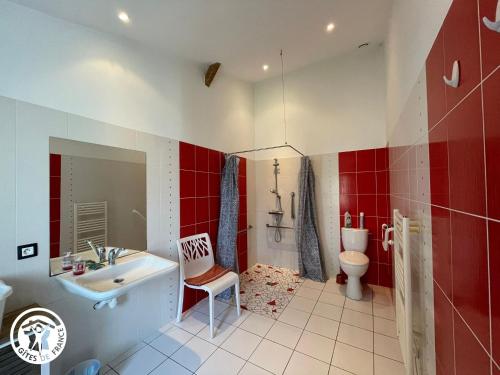 ein Bad mit einem Waschbecken, einem WC und roten Wänden in der Unterkunft Gîte rénové avec spa, piscine chauffée, WiFi et accès handicapés au cœur du Marais Breton - FR-1-426-321 in Soullans