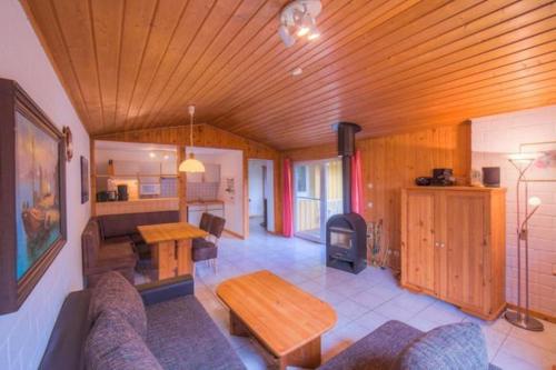 a living room with a wooden ceiling and a table at Ferienpark Mirow, Granzow in Granzow