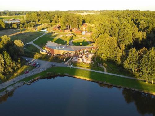 an aerial view of a house with a lake at Forest-Edge Retreat, Antoing in Antoing