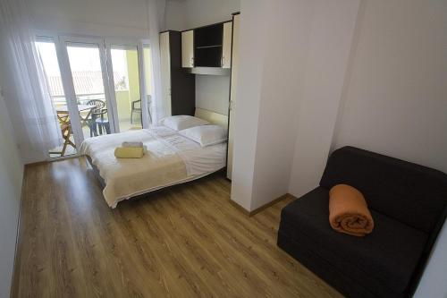 a small bedroom with a bed and a couch at Apartments Rubic in Omiš