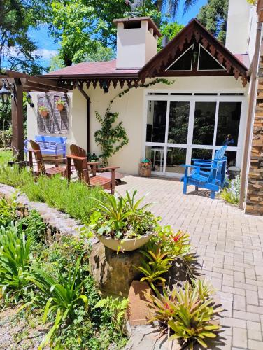 a patio with two blue chairs on a house at Quintal do Garnizé - Unidade Beija-Flor in Nova Petrópolis