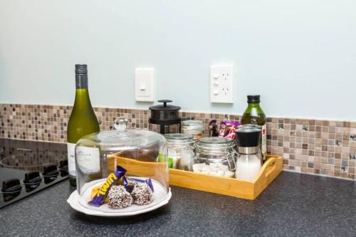 a kitchen counter with a tray of food and wine bottles at Waikawa Beach Pod in Manakau