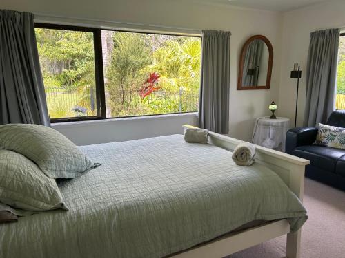 a bedroom with a bed and a large window at Harbour View Retreat Mangonui in Mangonui