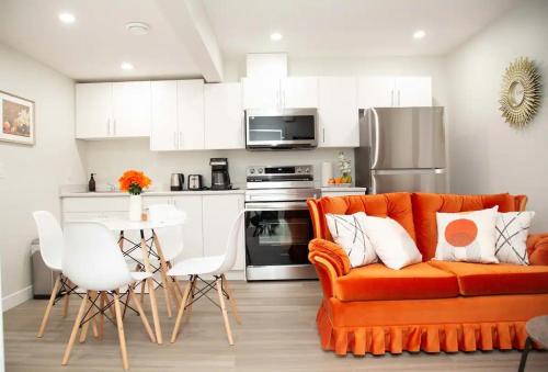 a living room with an orange couch and a kitchen at Love Villa in Saskatoon